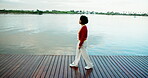 Calm, walking and thinking with woman at lake for travel holiday, adventure and reflection. Peace, wellness and inspiration with person on boardwalk in nature for mindfulness, vacation and relax