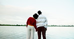 Couple, holding hands and back with lake view, vacation or bonding at park on boardwalk with love. People, man and woman with sightseeing outdoor, support or connection with sky by water on holiday