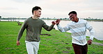 Men, friends and fist bump at lake on holiday, walk or reunion in nature for trip on journey. Outdoor, happy people and greeting together on vacation, bonding or travel on adventure with hand gesture