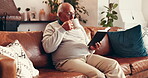 Coffee, reading and relax with senior man on sofa in living room of home for literature hobby. Book, retirement and storytelling with elderly person drinking caffeine beverage in apartment for break