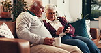 Coffee, mobile and elderly couple in home for relax, conversation and happy together with embrace. Drink, man and woman in retirement with phone for reading news, article and puzzle app on internet