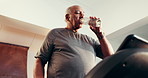 Senior man, drinking water and fitness on treadmill for health, walking and check smart watch. Hydration, workout machine and person in home for cardio, track heartbeat and retirement with low angle