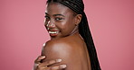 Skincare, shoulder and smile with face of black woman in studio for body care, dermatology and glow. Beauty, shine and hydration with person on pink background for collagen, treatment and cosmetics