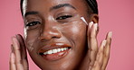 Face, black woman and apply cream for skincare, hydration or collagen treatment for dermatology. Portrait, happy model or lotion for cosmetics, beauty or moisturizer on pink studio background closeup