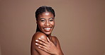 Shoulder, beauty and smile with face of black woman in studio for skincare, body care and hygiene. Glow, dermatology and shine with female model on brown background for mockup space and grooming