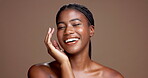 Smile, glow and hands with face of black woman in studio for beauty, skincare and dermatology. Shine, hydration and grooming with person on brown background for self care, cleaning and detox