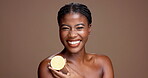 Happy, confident and black woman with lemon for vitamin c, brightening face or beauty in studio. Brown background, healthy glow and female person with fruit for detox, cosmetics or diet for skincare