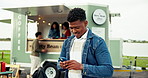 Happy, outdoor and man with phone for networking, social media or communication by food truck. Smile, contact and male person waiting for date with cellphone for texting at mobile coffee shop.