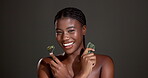 Tools, beauty and face of black woman in studio for lymphatic drainage, skincare and detox. Gua sha, glow and jade roller with person on dark background for facial massage and holistic treatment 