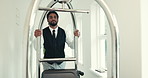 Man, hotel and service with luggage trolley, push and bag delivery for client at job in hallway at luxury lodge. Person, cart and baggage for guest, customer and concierge at accommodation resort