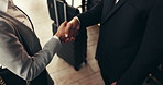 Handshake, hotel and business people in lobby for greeting, partnership and networking at convention. Work trip, corporate event and workers shaking hands with suitcase for deal, meeting and welcome