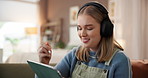 Headphones, tablet and woman on sofa in home with networking, relax and listening to music. Happy, digital technology and female person with stylus for drawing with streaming playlist in living room.
