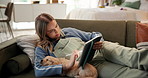 Woman, tablet and puppy on sofa in home, drawing and creativity with application in living room. Girl, digital artist and tech with sleeping dog, golden retriever and sketch with inspiration in house