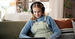 Laptop, learning and music with woman on sofa in living room of home for online course or study. Computer, headphones and remote education with college student in apartment for university scholarship