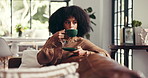 Thinking, coffee and black woman on sofa in home for wellness, peace and relaxing on weekend. Living room, morning and person with tea, beverage and drink on couch for calm, satisfaction and break