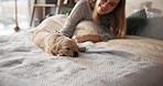 Break, love and woman in bed with puppy for bonding, home companionship or weekend wellness. Loyalty, relax and scratching dog with pet owner in bedroom of apartment for safety, security or trust