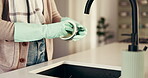 Washing, dishes and person with chores in kitchen, hygiene or cleaning with gloves in home and sink. Morning, routine and hands with chemical for bacteria prevention, disinfection and housework