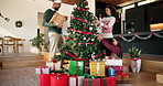 Gifts, christmas tree and parents with child for decoration in home with bonding in festive season. Smile, presents and family with baubles for xmas aesthetic in living room together at house.