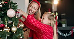 Mother, child and tree with decoration on Christmas, festive celebration and holiday tradition. Smile, woman and hug kid with sparkle ornaments, help prepare and family bonding of xmas season in home