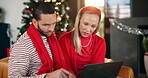 Christmas, laptop and search with couple on sofa in living room of home for festive shopping. Computer, ecommerce and gift buying with people in apartment together for December payment or purchase