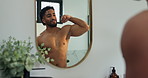 Man, mirror and flexing biceps in bathroom for fitness progress, muscle growth and workout results. Male person, reflection or inspection of body transformation, grooming routine and strength in home