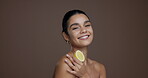 Face, woman and lemon for skincare in studio for vitamin c, brighten skin and natural detox. Portrait, person and citrus fruit with organic benefits, beauty and exfoliate treatment on brown background