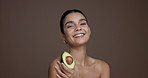 Face, skincare and woman with avocado, smile and natural cosmetic for anti aging, wellness and glow. Studio background, happy and person with fruit for dermatology, mockup space or treatment for skin