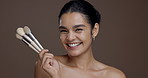 Woman, makeup brush and face with laugh in studio, results and transformation with beauty by background. Girl, model and space for cosmetics, foundation or portrait for pride, skin and happy in Peru