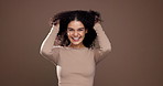 Woman, face and excited for hair care, studio and touch for volume, growth and space on background. Girl, person and happy with curly hairstyle, confidence and benefits with texture in Costa Rica