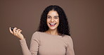 Happy woman, spray and studio with cologne for aroma, ordor or fragrance on a brown background. Portrait, female person or model with smile, perfume or product for hygiene or scent on mockup space 