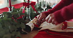Christmas, decoration and hands of woman by table for lunch, celebration and party for holiday. December, dining room and person with napkin, plate and crackers for tradition, festive season and xmas