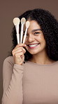 Face, beauty and woman laughing with makeup brush for shine, foundation and glow in studio. Portrait, cosmetics tools and excited model wink with product for self care and aesthetic on background