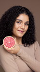 Beauty, grapefruit and face of woman in studio for natural, health and facial glow with hydration. Organic, skincare and portrait of person with citrus fruit for brightening by brown background.