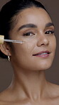 Serum, skincare and face of woman in studio for beauty, vitamin c dropper and self care cosmetics. Hyaluronic acid, collagen benefits and facial product with person on brown background for dermatology