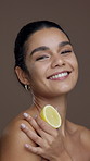 Lemon, studio and face of happy woman for skincare, facial detox and anti aging on brown background. Dermatology, beauty and portrait of person with citrus for vitamin c, natural glow and hydration