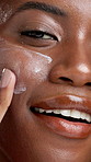 Cream, apply and face of black woman for skincare, facial treatment and anti aging cosmetics. Dermatology, closeup and portrait of person with lotion, spf and moisturizer for hydration, glow or shine