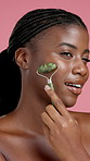 Jade roller, skincare and beauty with black woman for face, lymphatic drainage or detox. Smile, model and cosmetics stone for facial massage, dermatology treatment and glow on pink studio background