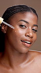 Face, black woman and apply serum for skincare, 
salicylic acid or vitamin c. Portrait, cosmetics and happy model with dropper for essential oil, anti aging and hydration on brown studio background