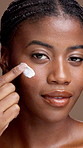 Face, skincare and black woman with cream for beauty, sunscreen or laugh. Portrait, cosmetics and smile with lotion for dermatology or apply collagen moisturizer for health on brown studio background