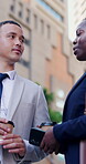 Businessman, woman and discussion with coffee in street, low angle and networking on commute in town. People, outdoor and talk with drinks, questions or smile on urban sidewalk with travel in city