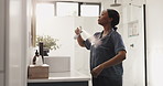Home, deodorant and black woman in bathroom with spray for scent, fragrance and grooming. Morning routine, health and person with cosmetic products, perfume and fresh for hygiene, wellness and smell