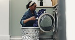 Black woman, basket and laundry with washing machine in home for cleaning routine, hygiene and fabric. African person, clothes and linen with container for chores, dirt and housework at apartment