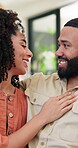 Laughing, couple and chat in living room, love or bonding on weekend in home, relationship and care. Happy, man and talking to woman in lounge, smile and conversation in house, relax and chilling
