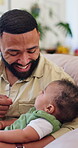 Father, baby and playing with cheek on home sofa for bonding, love and care of proud parent. Happy man, healthy son and together in family house with protection, smile and childcare in living room
