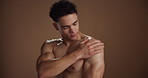 Skincare, cream and man in studio, cosmetics and dermatology on brown background. Space, wellness and person with shine, creme and lotion with glow, grooming, muscular and healthy skin with aesthetic