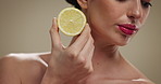 Woman, hands and lemon with vitamin C for skincare, diet or citrus nutrition on a studio background. Closeup, female person or model with natural organic fruit for detox, citric acid or healthy skin