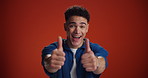 Happy man, face or promotion with thumbs up in studio for good job or well done on a red background. Portrait, male person or model with smile, like emoji or yes sign for success on mockup space