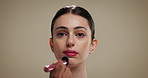 Woman, makeup artist and brush in studio with foundation, beauty and application on background. Girl, facial concealer and powder for cosmetics, change or mockup space for product with transformation