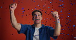 Dancing, face and man with confetti celebration on studio background for winner, deal and success. Announcement, contestant and excited with victory fist for lottery prize, game show offer and reward