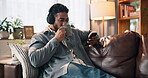 Coffee, headphones and phone with man on sofa for streaming, music playlist or relax. Audio subscription, calm podcast and connection with person in living room of home for album, sound and listening